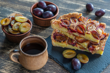 Homemade organic plum pie dessert ready to eat. Plum tart on the old wooden background, close up