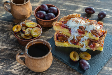 Homemade organic plum pie dessert ready to eat. Plum tart on the old wooden background, close up