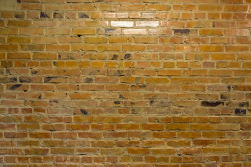 Old yellow brick wall. Faded yellow color, a bit dirty. Interior