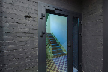 Door with glass and gray painted brick wall.