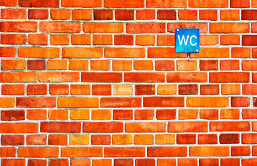 Fototapeta na wymiar Red brick wall with toilet sign.