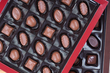 Brown chocolate candy background. Assortment of chocolate candies sweets in the box