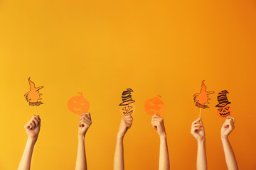 Many hands with Halloween decor on color background