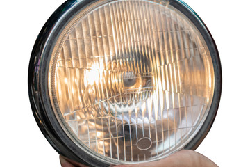 Headlight motorcycle lamp on hands with isolated background.
