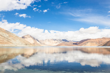 Fototapeta na wymiar Reflections of high mountain with white cloud and blue sky on the Pagong lake, Leh Ladakh, India.