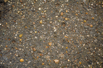 Texture of dry gray asphalt with pebbles and small stones. Concept of abstract rough scabrous surface. Minimalistic background design with copy space. Eclectic flat lay in loft style, gravel top view