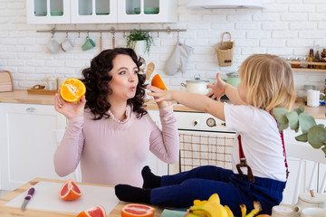 Mom and son playing together with oranges.