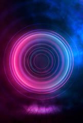 Neon circle on a dark street background, wet asphalt. Blue neon, smoke, smog. Night view of a street with neon. Abstract neon dark background.