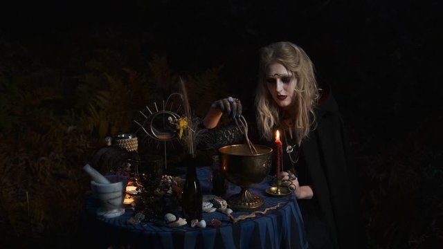 Halloween Image. Young Witch Prepares Magic Drink In Bowls.