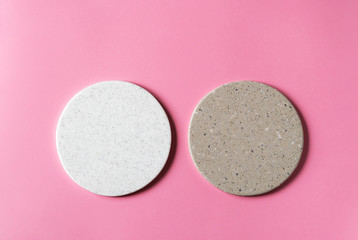 Obraz na płótnie Canvas Round coasters made of artificial stone tabletop on a pink background. Food stand.