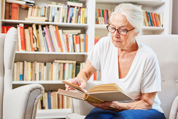Senior woman reads concentrated in a book