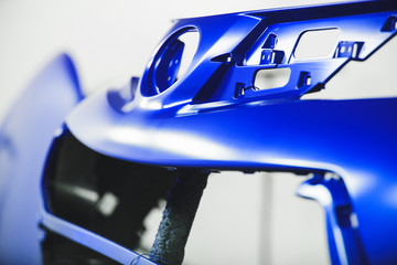 Fototapeta premium Car element body after painting with blue paint. Drying parts of the automobile in spray booth.
