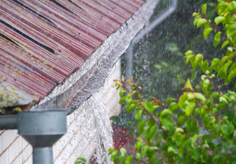 Close up of water overflowing from old gutter during a heavy rainfall