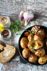 Baked potatoes in a peel in a cast-iron skillet. Rustic potatoes. Selective focus. Macro.