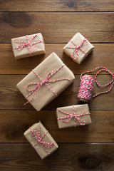 Christmas background. Gift boxes wraped in craft paper over wooden background. Top view, rustic style.