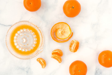 Citrus Glass Juicer and Clementines on White Marble Background