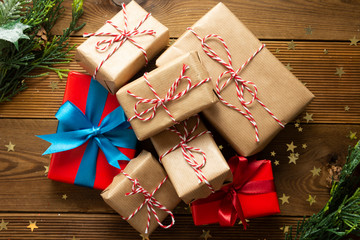 Group of Christmas and new year gift boxes wraped in craft paper, wooden table prepared for celebrating festive holiday season. To view.