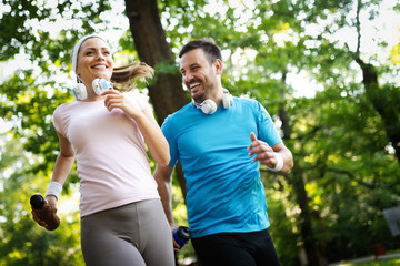 Happy couple jogging and running outdoors in nature