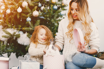 mother gifting a bunny as a present to blonde young daughter