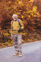 Obraz premium Senior man hiking in autumn forest.