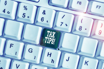 Handwriting text writing Tax Tips. Conceptual photo compulsory contribution to state revenue levied by government White pc keyboard with empty note paper above white background key copy space