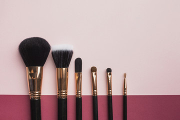 Flat lay frame with make-up brushes and pink background