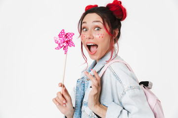 Image of cute woman holding flower wind spinner and looking at camera