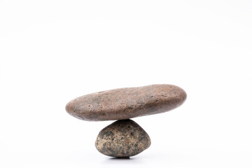 A picture of two pebbles placed together with the natural balance of weight.