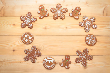 Frame of sweet Christmas gingerbread biscuits on wooden background