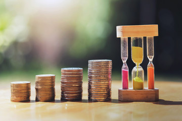 money stack with hourglass on table  and sunset
