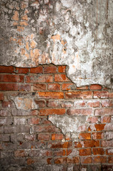 Old brick wall in a background image. Plastered Brickwall With Chipped Stucco Pieces. Red Textured Brick Wall With Damage Surface. Old Grunge Abstract Background