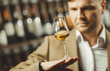 Portrait of male sommelier tasting whiskey at cellar.