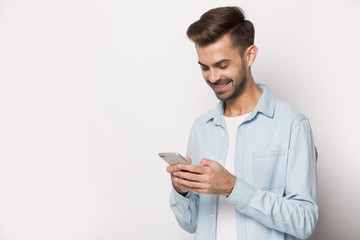 Smiling man texting using modern smartphone wireless internet