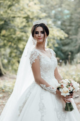 Happy bride in a beautiful dress walking in the park. Happy wedding. Young beautiful stylish woman, bride, bridal fashion, summer trend, flowers, roses, hairstyle, beauty make-up, white dress. 