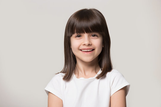 Headshot portrait of happy little girl posing in studio