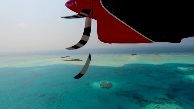 Seaplane or hydroplane landing on a water on Maldives or  Seychelles island resort. 