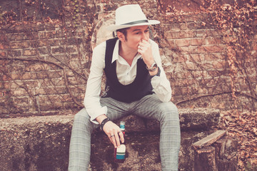 Pensive man with beer bottle thinking outdoors.