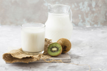 Fresh blended kiwi protein smoothie with yogurt or milk in glass jar, healthy eating on white...