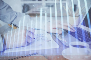 Multi exposure of stock market graph with man working on laptop on background. Concept of financial analysis.