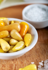 Marinated chili peppers with fresh green peppers on wooden background.