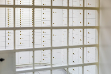 Storage room with safe  deposit boxes in a bank. Room with rows of individual cells locked onto metal door lattice