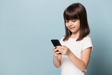 Fototapeta premium Little girl using modern smartphone watching cartoons