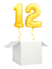 Golden number twelve inflatable balloon with golden ribbon flying out of blank white box isolated...