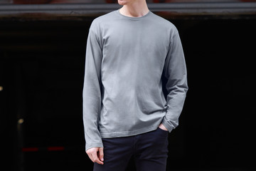 Hombre llevando una camiseta de manga larga imprimible en color azul tejano sobre un fondo oscuro