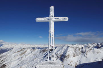 Frozen cross at the mountain top