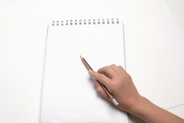 Hand with a pencil on a white background. Women hand holding a pencil on blank sheet of paper