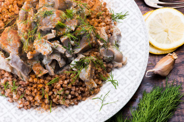 Stewed turkey stomachs with vegetables and buckwheat in a bowl