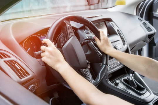 Female hands with steering wheel close up. Woman driving car and holding tight car steering wheel