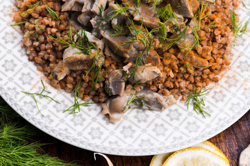 Stewed turkey stomachs with vegetables and buckwheat in a bowl