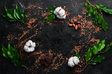 Sea salt with cocoa beans. On a black stone background. Spa treatments. Top view. Free copy space.